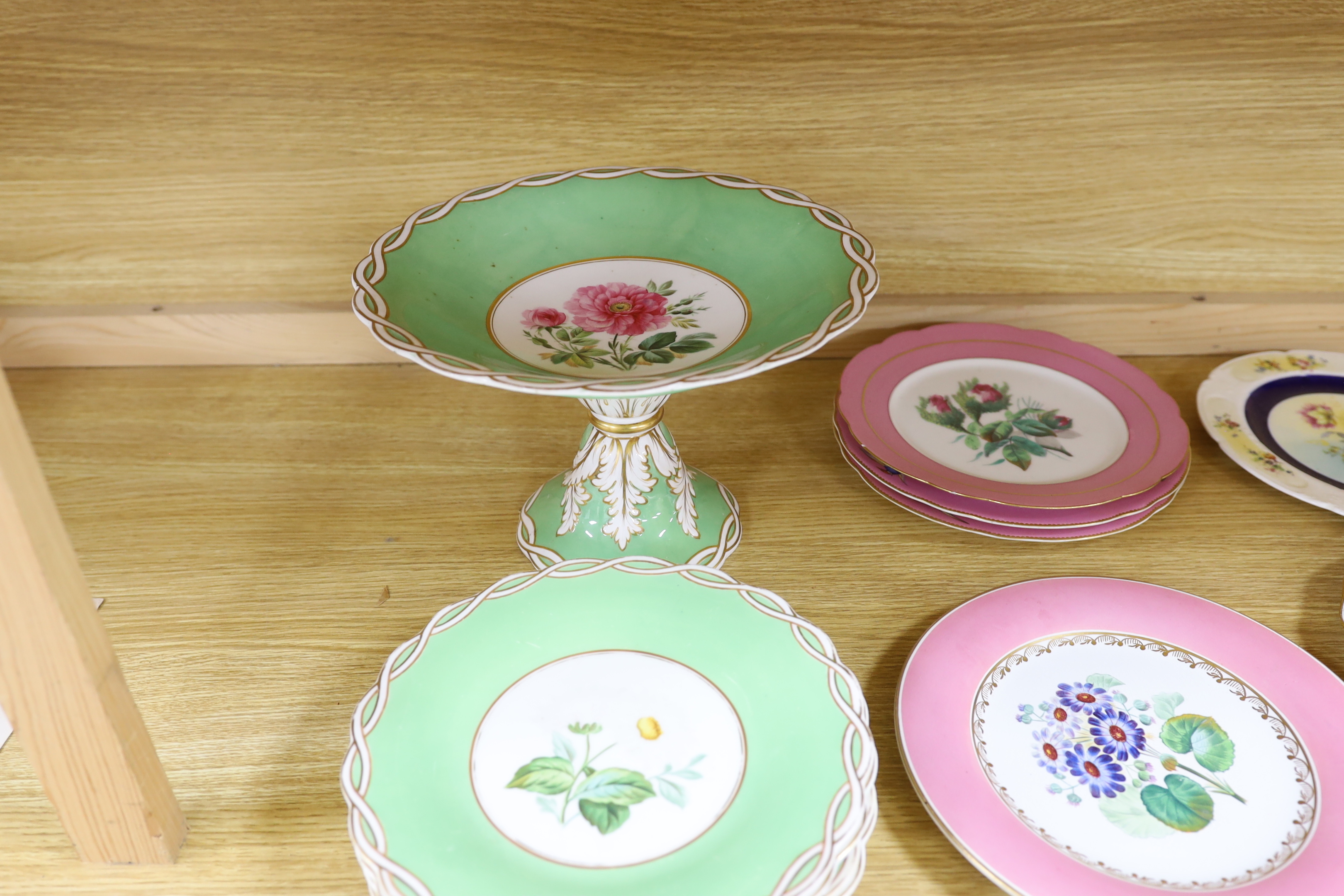 An English floral decorated comport and nine dessert plates, together with ten mixed floral patterned plates, largest 28cm in diameter